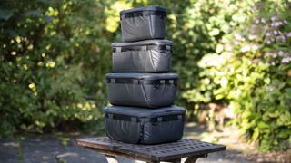 Tower of Peak Design Camera Cubes on wooden table outside