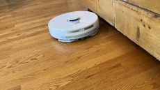 Narwal Freo X Plus robot vacuum and mop cleaning next to furniture in reviewer's home